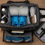 Versatile gym weekender bag with multiple compartments for fitness gear and travel essentials displayed on wooden surface