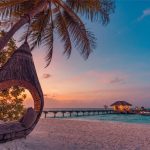 Romantic Hawaii beach sunset with couple walking along the shoreline