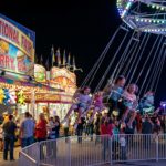 Families enjoying thrilling midway rides and carnival games lit up at night at the Georgia National Fair 2026 in Perry, Georgia
