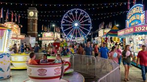 Families enjoying the midway rides and carnival attractions at the Georgia National Fair 2026 at night under the lights in Perry, Georgia
