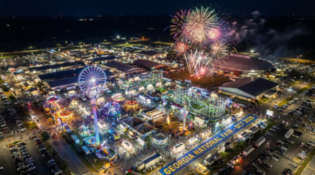 Aerial view of the Georgia National Fairgrounds in Perry Georgia lit up at night with midway rides and fireworks during the October 2026 fair